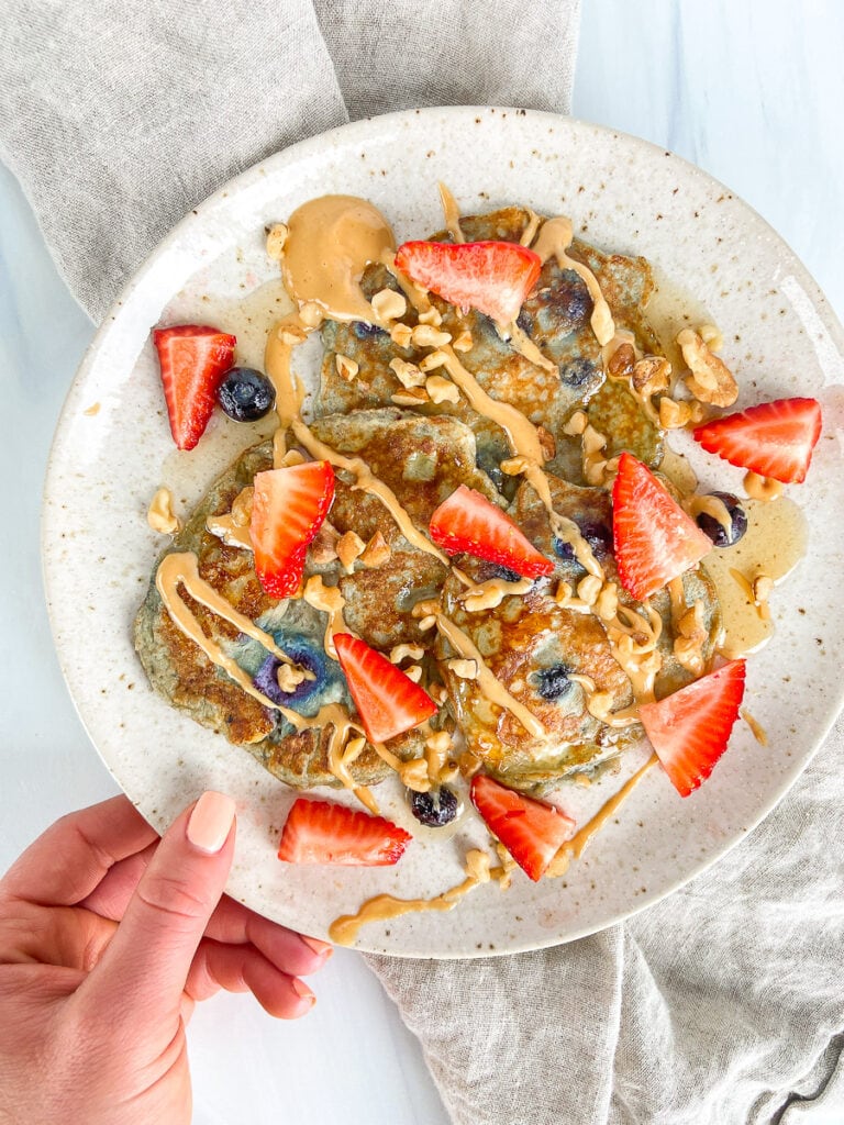 4-ingredient pancakes, baby-friendly, baby led weaning recipe, plated with toppings - strawberries, walnuts, peanut butter 